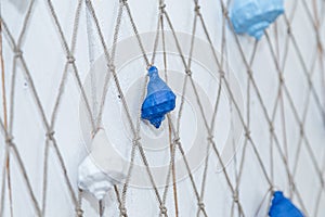 Thematic sea party decorations, blue and white painted sea shells hanging on fish net. Boy birthday party