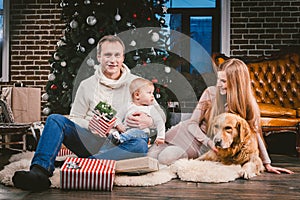 Theme Christmas and New Year family circle and domestic pet. Mom dad and child 1 year old Caucasian woman sitting on