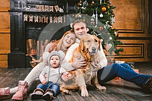 Theme Christmas and New Year family circle. Young Caucasian family with 1 year old child dog breed Labrador Golden Retriever