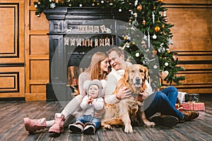 Theme Christmas and New Year family circle. Young Caucasian family with 1 year old child dog breed Labrador Golden Retriever