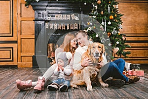 Theme Christmas and New Year family circle. Young Caucasian family with 1 year old child dog breed Labrador Golden Retriever