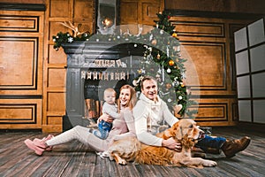 Theme Christmas and New Year family circle. Young Caucasian family with 1 year old child dog breed Labrador Golden Retriever