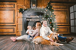 Theme Christmas and New Year family circle. Young Caucasian family with 1 year old child dog breed Labrador Golden Retriever