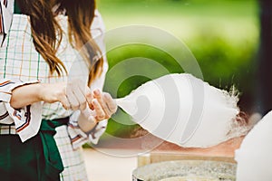 Theme is a family small business cooking sweets. Hands close-up Young woman trader owner of the outlet makes a candy floss, fairy