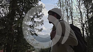 Theme of hiking and travel in nature in Germany. Male hiker walks in the mountains on a forest path near Schliersee lake