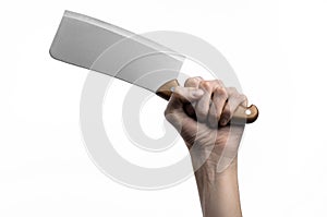 The theme of the kitchen: Chef hand holding a large kitchen knife for cutting meat on a white background isolated