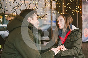 Theme love holiday Valentines Day. pair college students, Caucasian heterosexual lovers in winter, sit table of street cafe