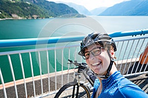 Theme of mountain biking in Scandinavia. human tourist in helmet and sportswear on bicycle in Norway on Hardanger Bridge