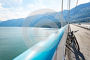 Theme of mountain biking in Scandinavia. human tourist in helmet and sportswear on bicycle in Norway on Hardanger Bridge