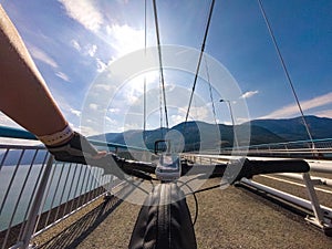 Theme of mountain biking in Scandinavia. human tourist in helmet and sportswear on bicycle in Norway on Hardanger Bridge