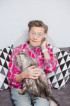 Theme old person uses technology. Mature contented joy smile active gray hair Caucasian wrinkles woman sitting home