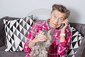 Theme old person uses technology. Mature contented joy smile active gray hair Caucasian wrinkles woman sitting home