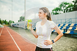 Theme is sport and health. Beautiful young caucasian woman with big breasts athlete runner stands resting on running