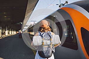 Theme transportation and travel. young caucasian woman standing at train station platform near train backs train background with