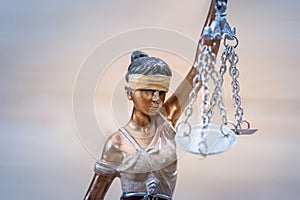 Themis figure on wooden background, close up