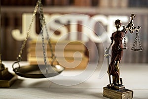 Themis figurine in the background of law books.