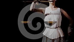 Themis, goddess of justice blindfolded, with scales and a sword in her hands.