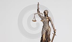 themis goddess of justice statuette on light background. symbol of the law with scales