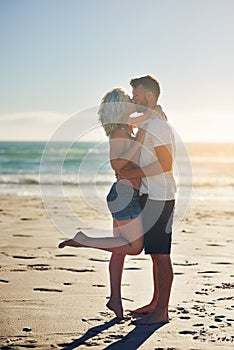 And then I knew that its true love. a loving couple sharing a kiss while spending time at the beach.