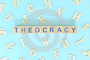 Theocracy government form concept. Wooden blocks typography flat lay in blue background.