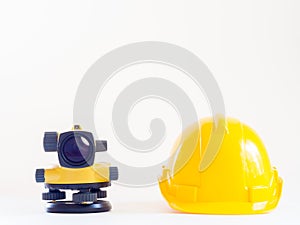 Theodolite and construction helmet on white background.