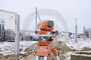 Theodolite on a tripod, set on a construction site