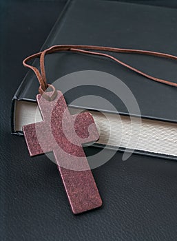 Theology concept. Wooden cross next to Holy Bible