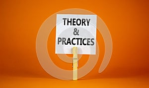 Theory and practice symbol. White paper with words `Theory and practice`, clip on wooden clothespin. Beautiful orange background