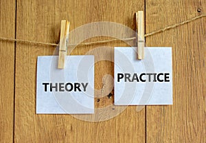 Theory and practice symbol. Wooden clothespins with white sheets of paper. Words `theory practice`. Beautiful wooden background.