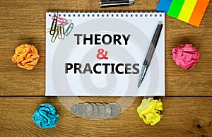 Theory and practice symbol. Words `Theory and practice` on white note. Wooden table, colored paper, paper clips, pen, coins.