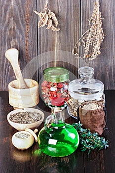 Therapeutic herbal tincture, alternative medicine, love potions, dried herbs on a wooden table.