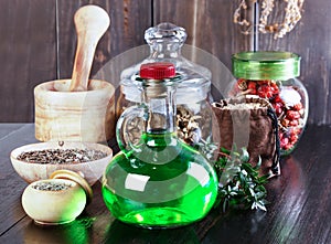 Therapeutic herbal tincture, alternative medicine, love potions, dried herbs on a wooden table.