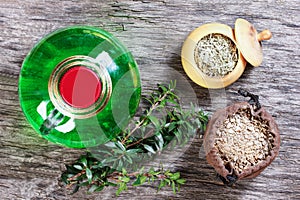 Therapeutic herbal tincture, alternative medicine, love potions, dried herbs on a wooden table.