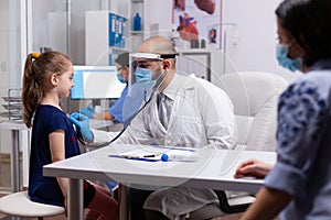 Therapeutist doctor consulting child with stethoscope for disease examination