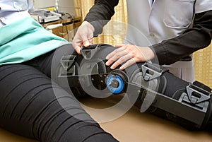 therapist adjust knee braces on patient `s leg,Rehabilitat