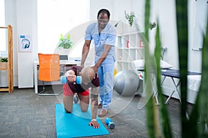 Therapist assisting patient with back injury doing exercises