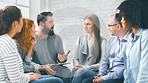 Therapist consulting patients of rehab group at therapy session