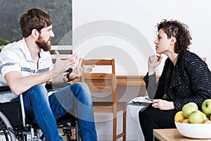 Therapist discussing with disabled patient