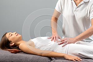 Therapist doing abdomen massage on little girl.