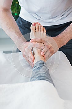 Therapist doing pressure and massage exercises through the feet to improve the overall health of the patient.