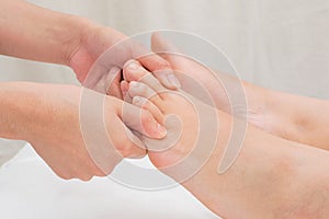 Therapist doing reflexology massage on woman foot