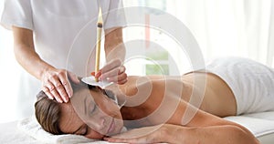 Therapist ear candling her patient