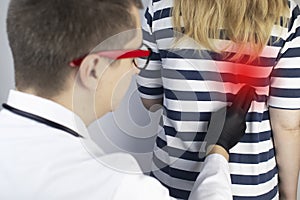 A therapist examines a patient who complains of kidney pain. The doctor will palpate to find out the source of the pain