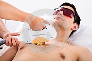 Therapist Giving Laser Epilation Treatment To Man