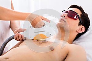 Therapist Giving Laser Epilation Treatment To Man