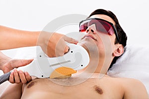 Therapist Giving Laser Epilation Treatment To Man