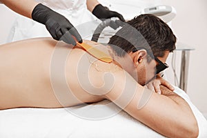 Therapist Giving Laser Epilation Treatment To Young Man In Spa