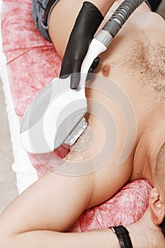 Therapist Giving Laser Epilation Treatment To Young Man In Spa