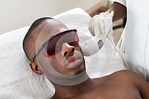 Therapist Giving Laser Epilation Treatment On Young Man