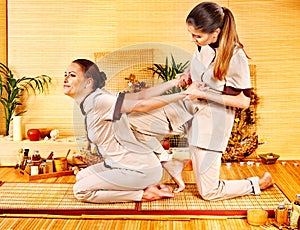 Therapist giving stretching massage to woman.